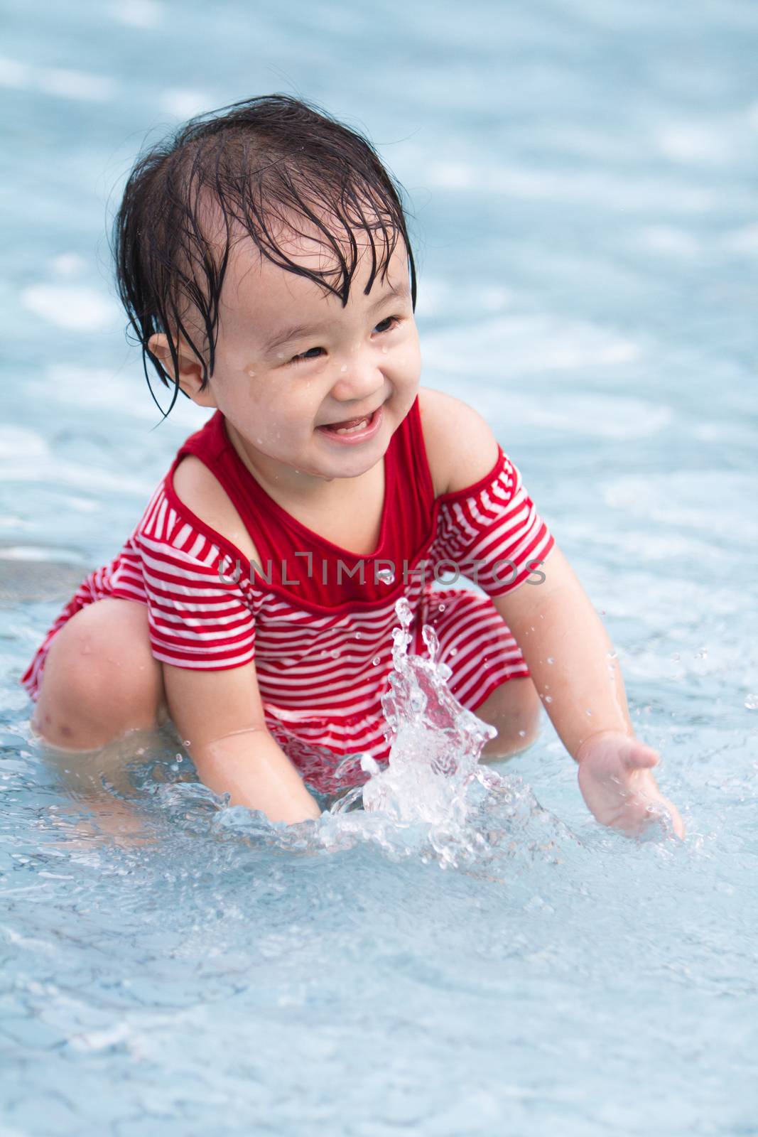 Chinese Little Girl Playing in Water in Swimming Pool