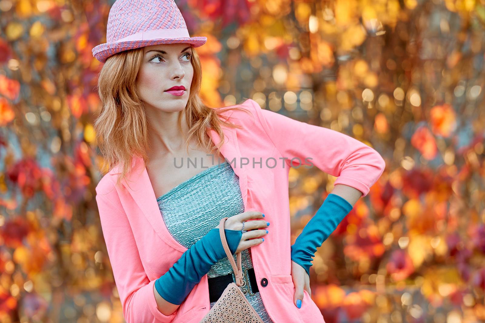 Fashion urban beauty people, woman, outdoor.Playful glamor hipster redhead girl in stylish hat, vivid jacket, gloves with trandy clutch. Sunny day autumn orange bokeh.Creative unusual, park, lifestyle