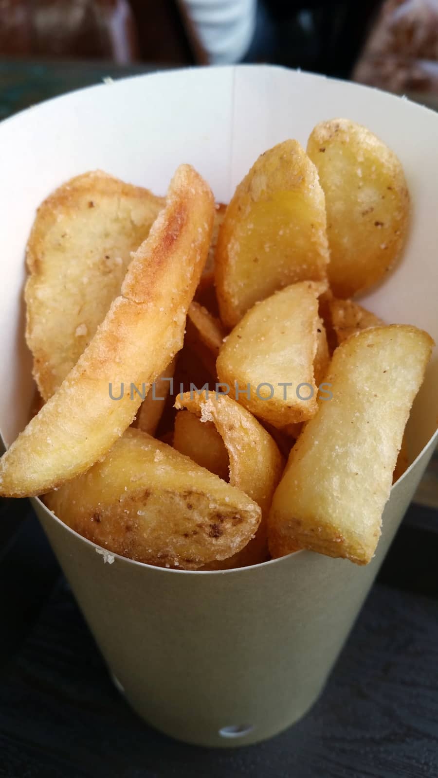Fried Potatoes Wedges in a Paper Wrapper