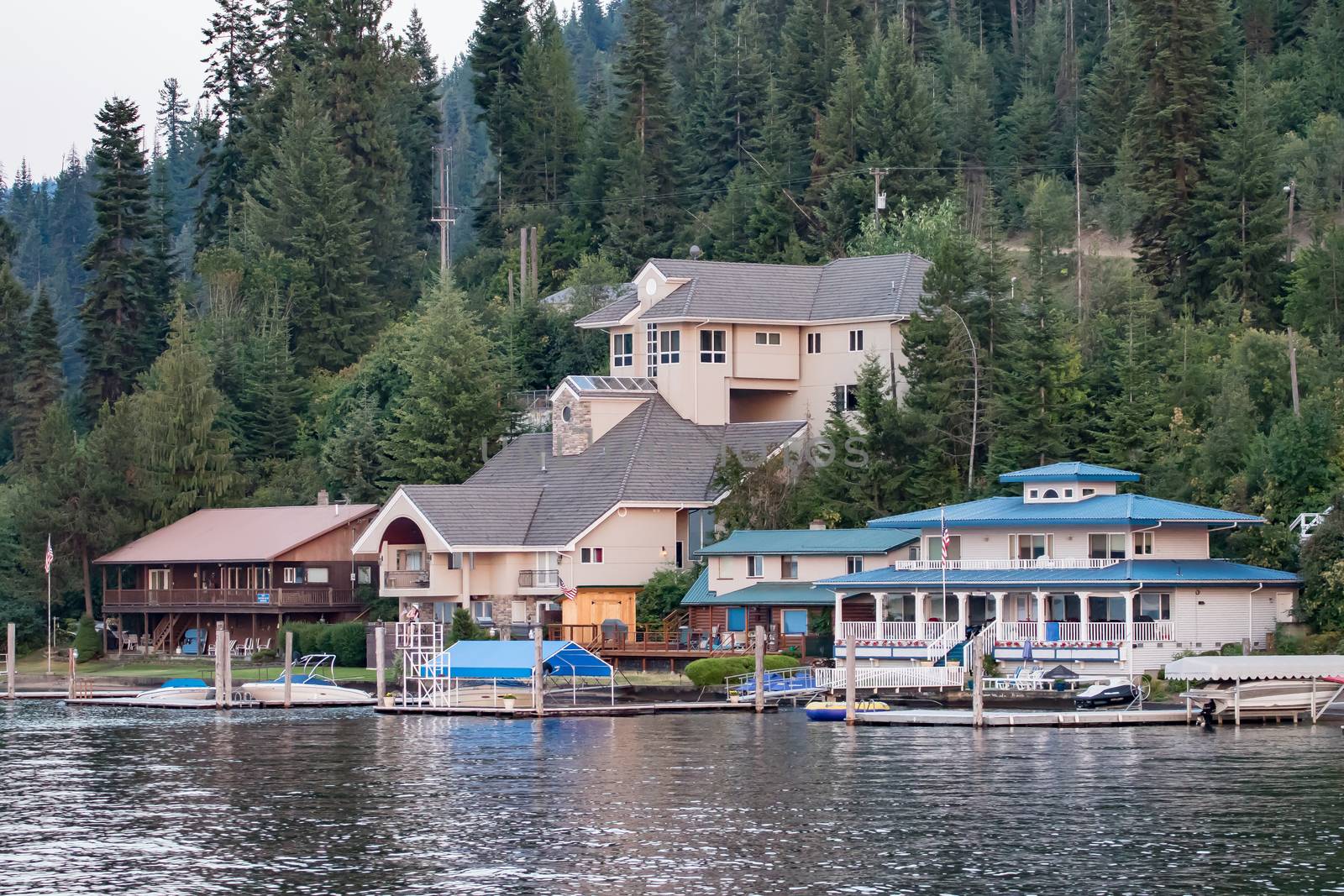 Coeur d'Alene, Idaho, USA-July 9, 2015: Homes and boat docks sit on the shores of Lake Coeur d'Alene as a mannequin guards the pier.