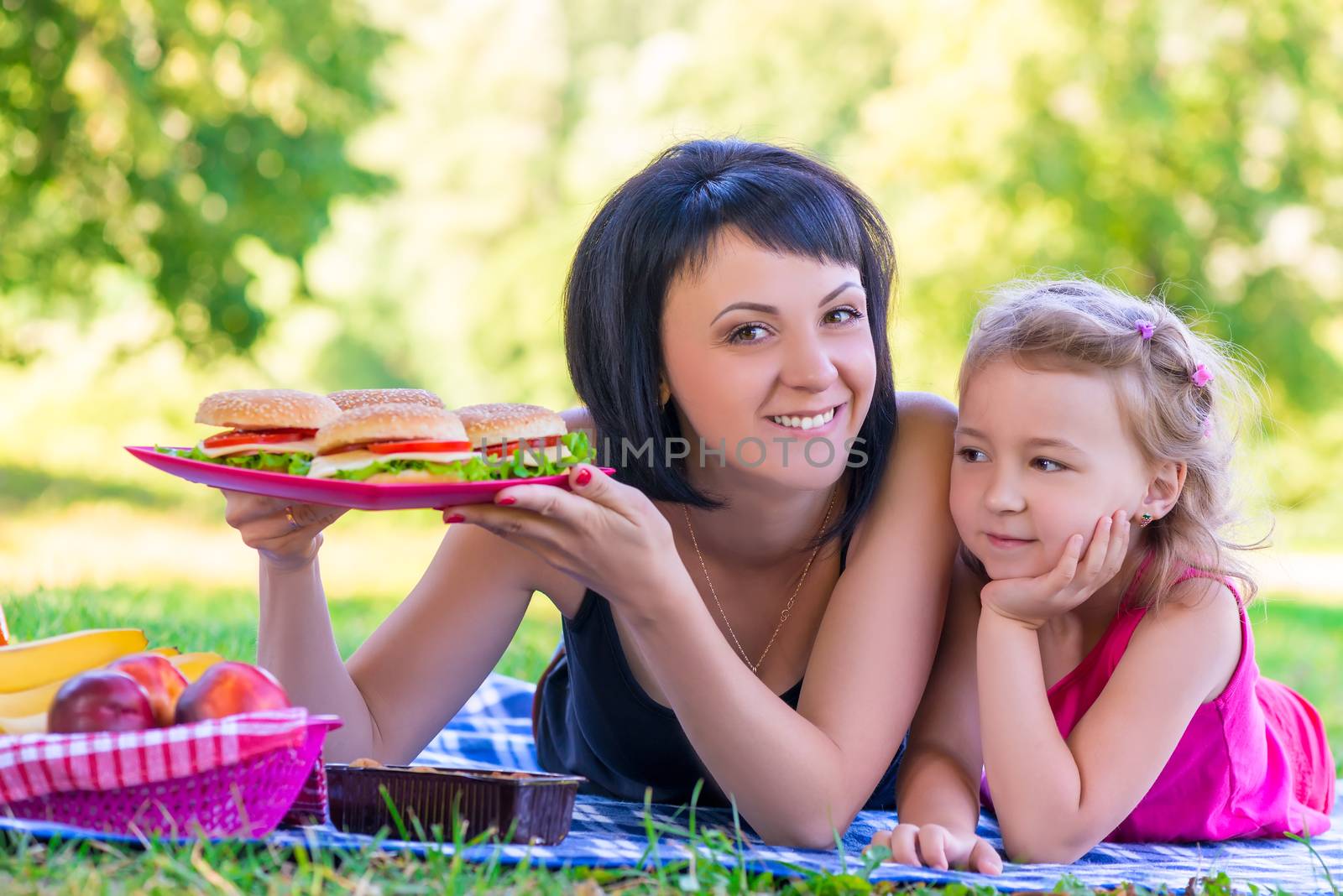 young beautiful mother holding a plate with burgers