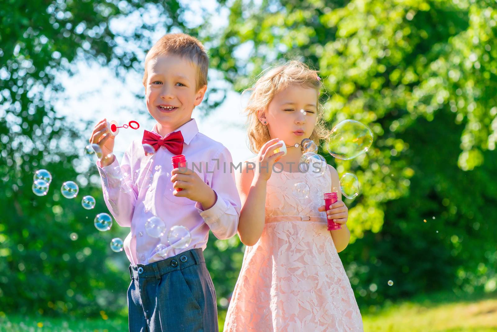 brother and sister 6 years in the park with soap bubbles