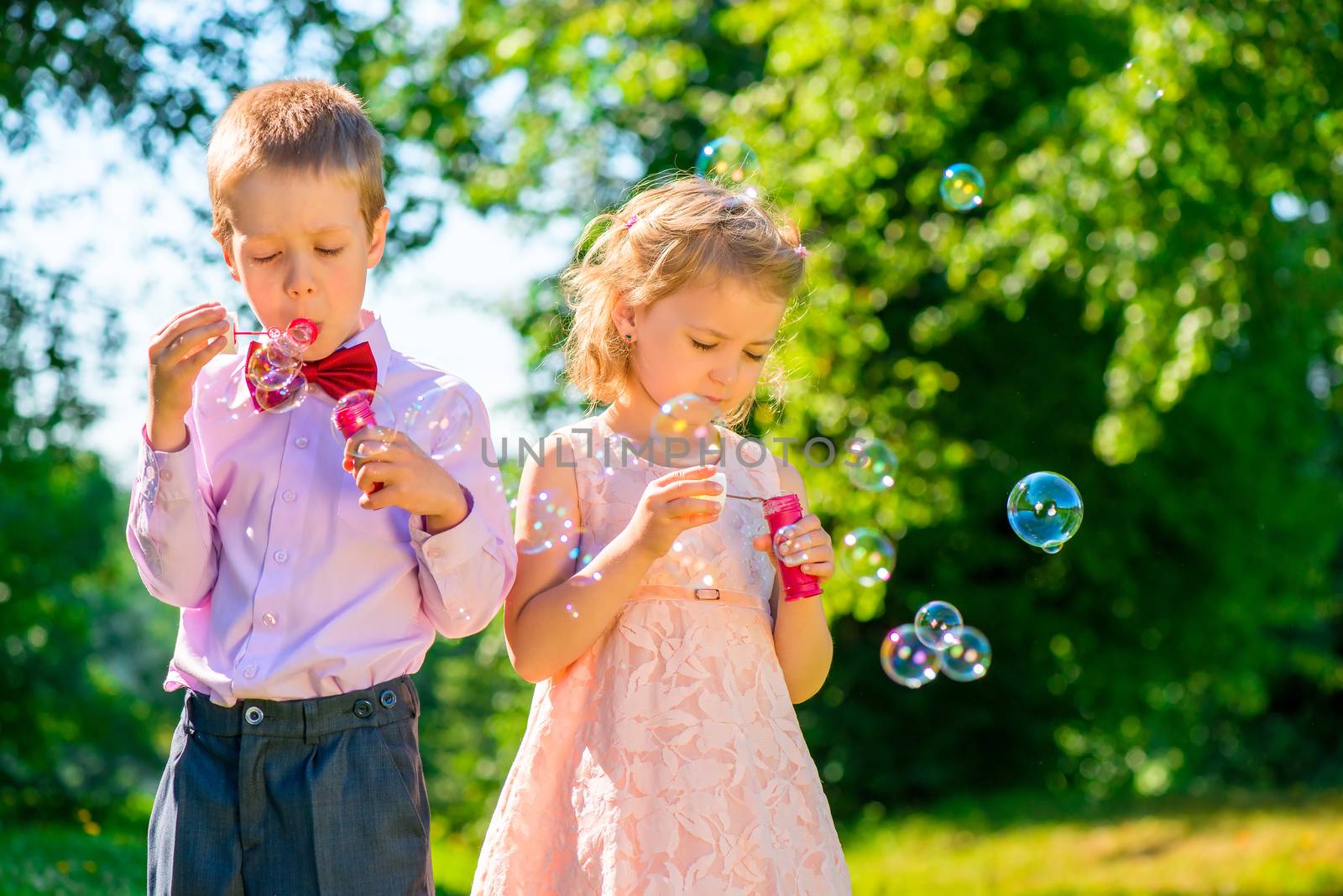 girl and her friend with soap bubbles in the park