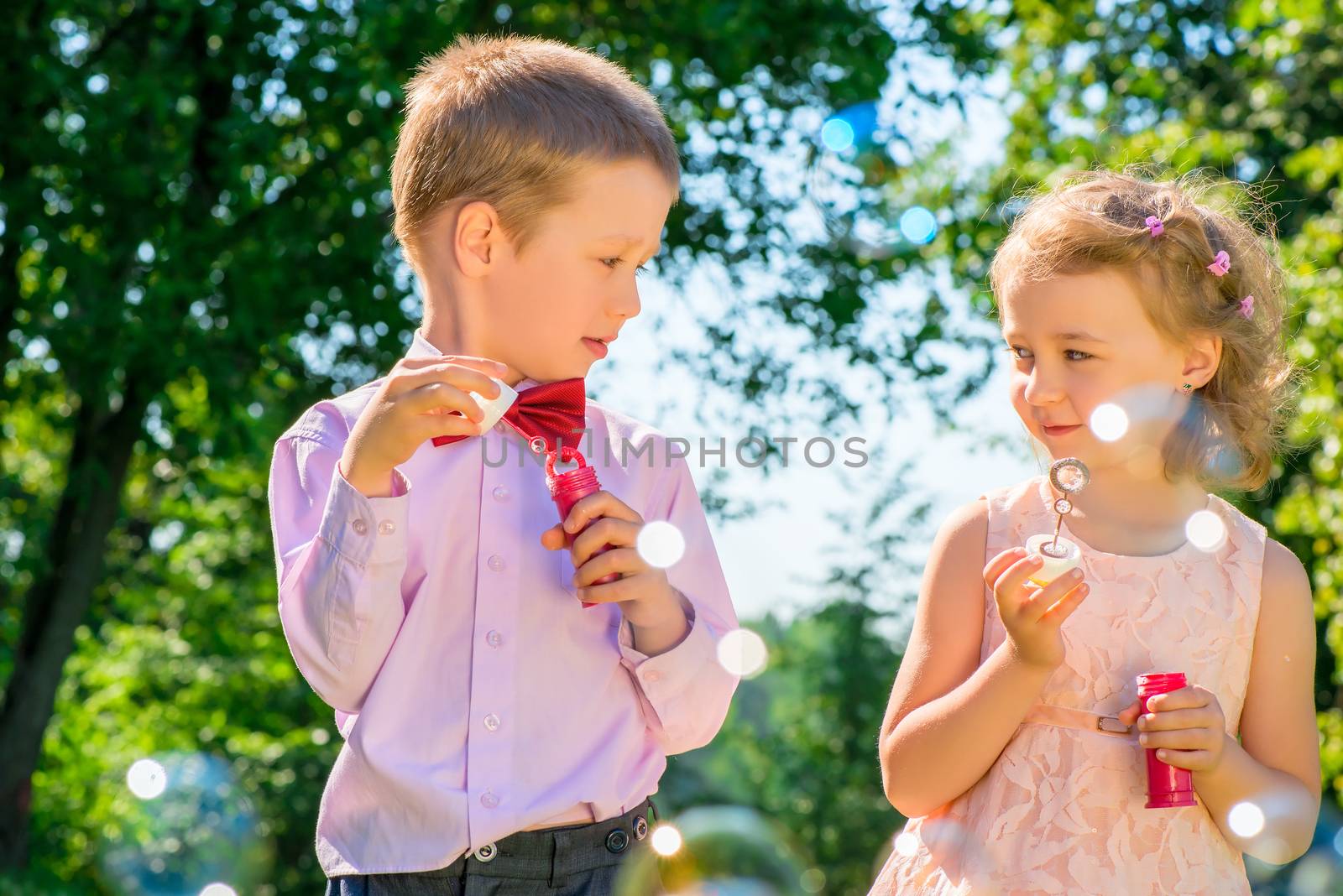 portrait of children with soap bubbles outdoors in the park by kosmsos111