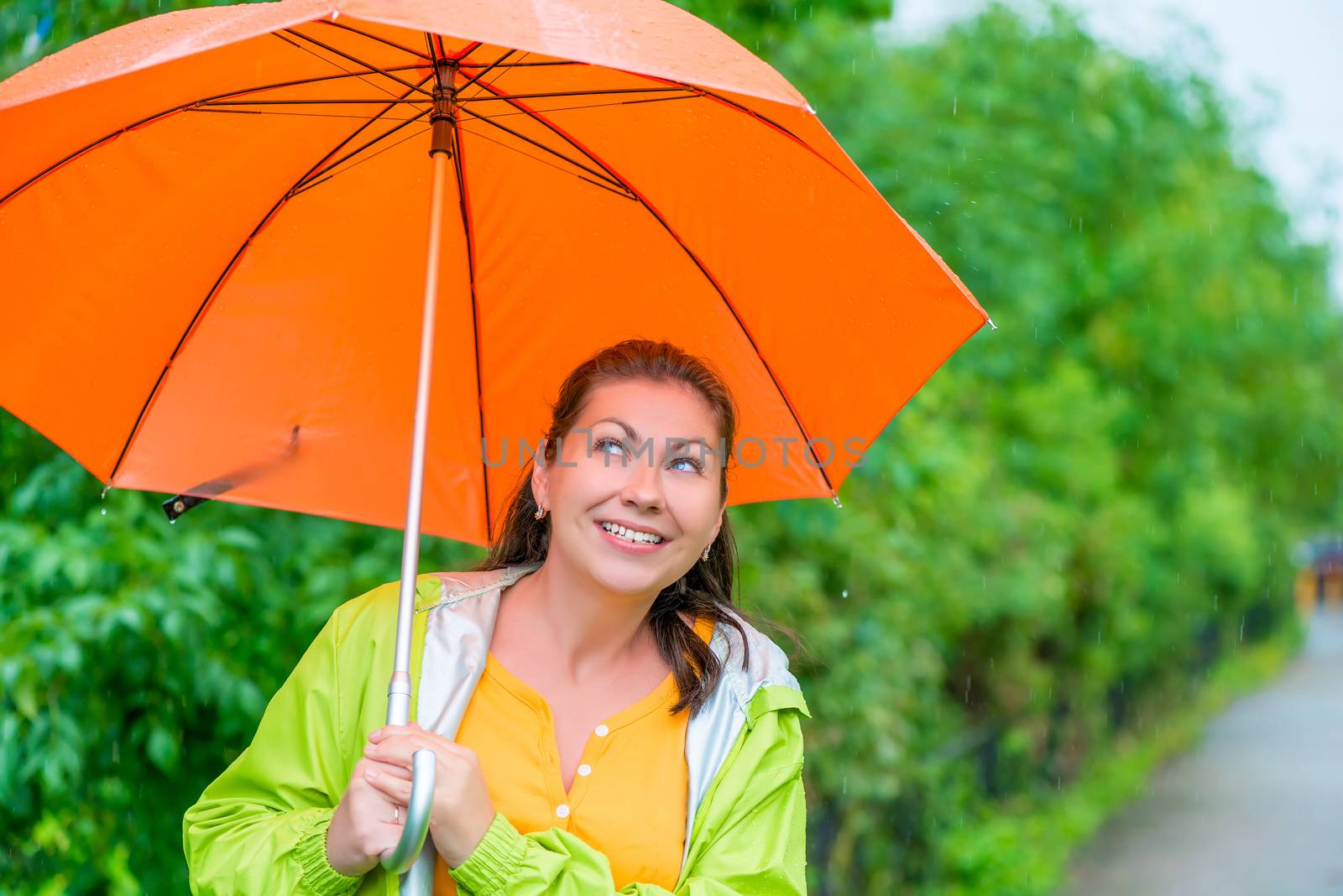 portrait of happy brunette wearing a raincoat under an orange um by kosmsos111