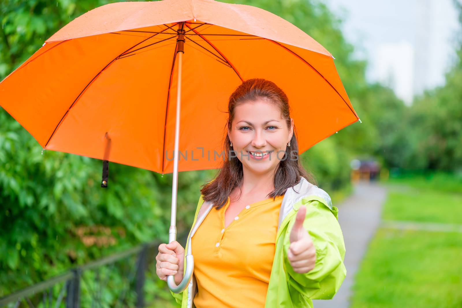 Satisfied woman with umbrella on the walk in the park by kosmsos111