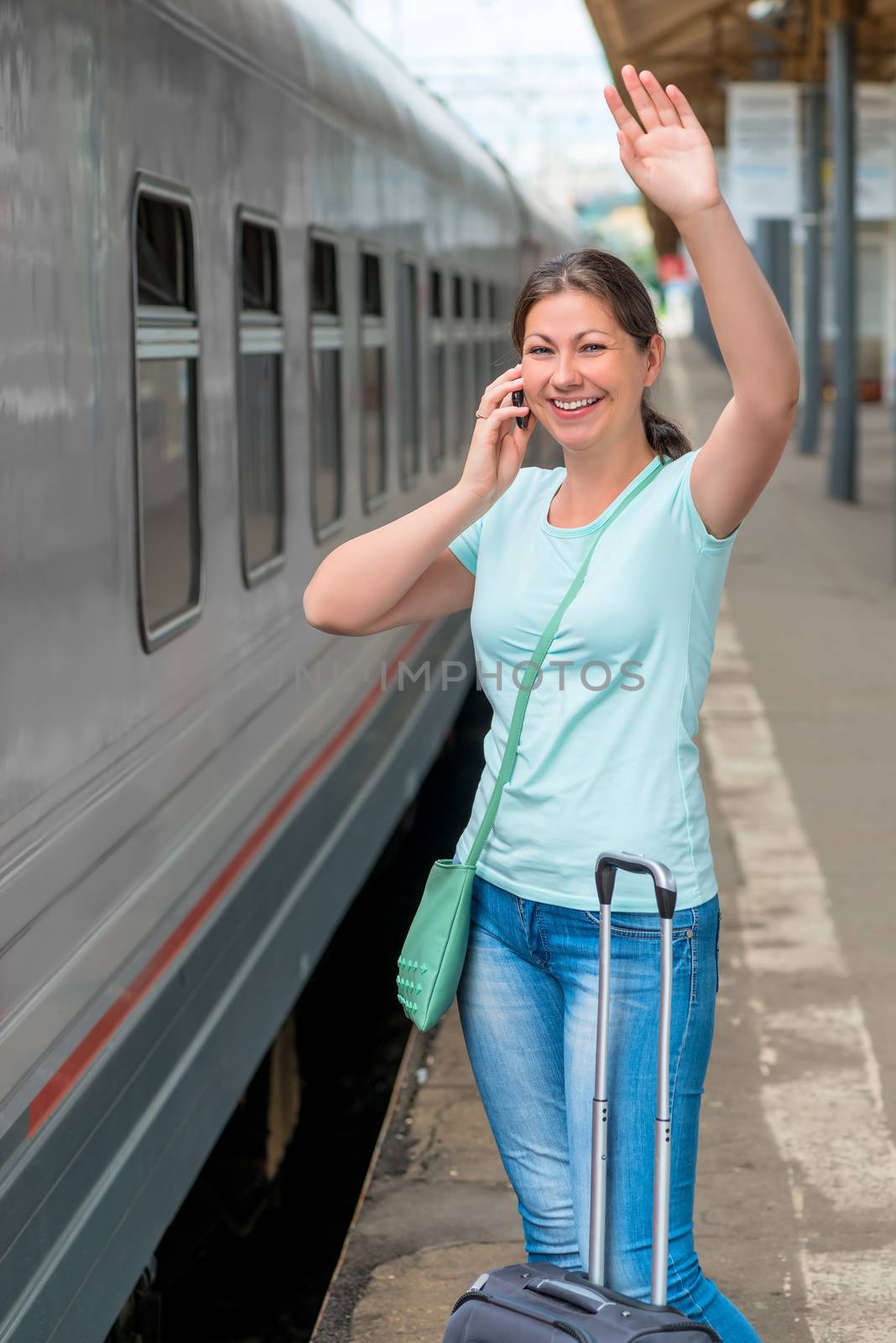 Girl with suitcase talking on the phone at the station by kosmsos111