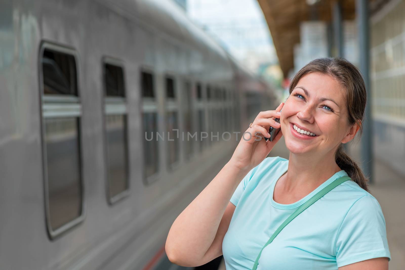 horizontal portrait of the girl with the phone near the train