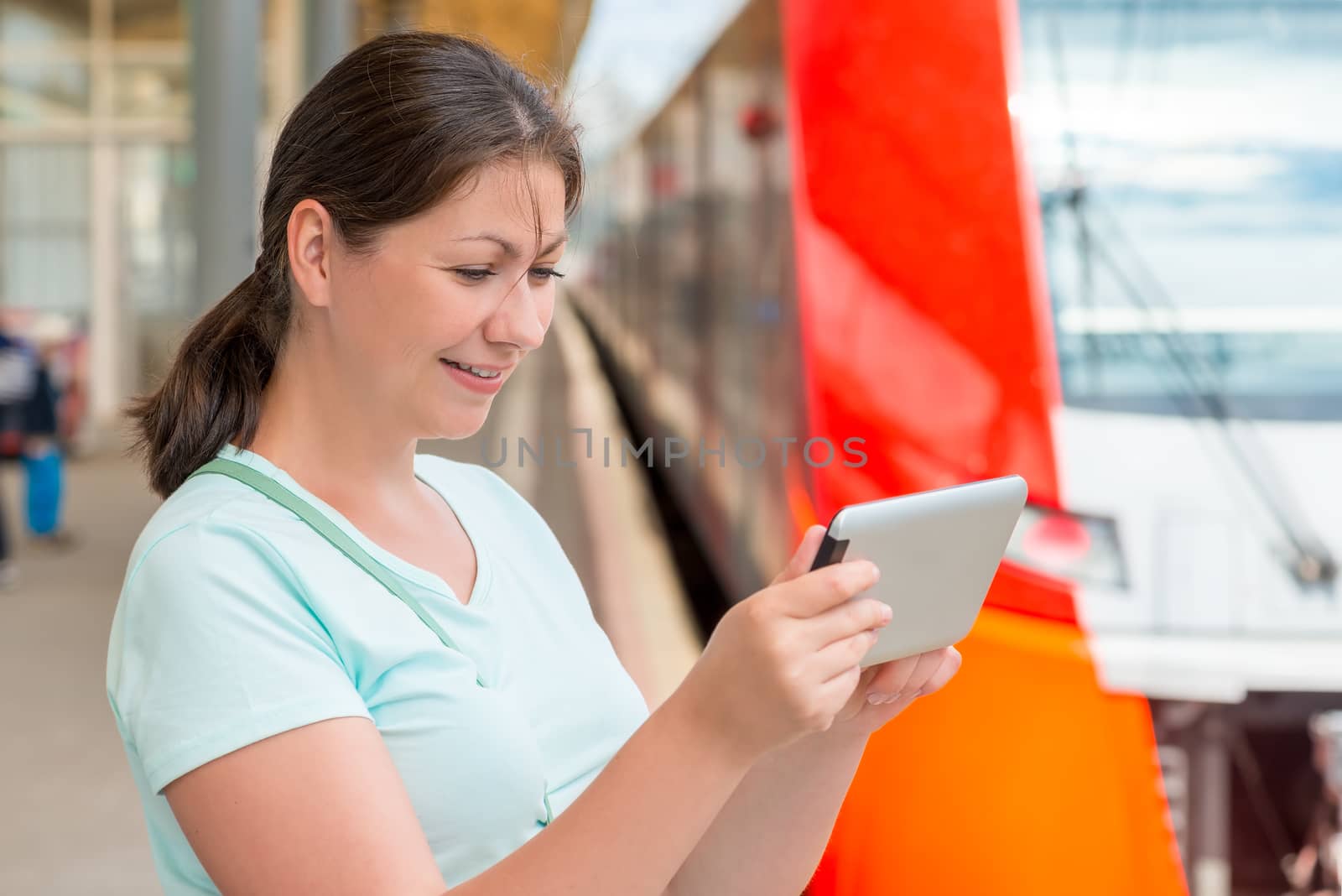 young woman with a tablet at the station