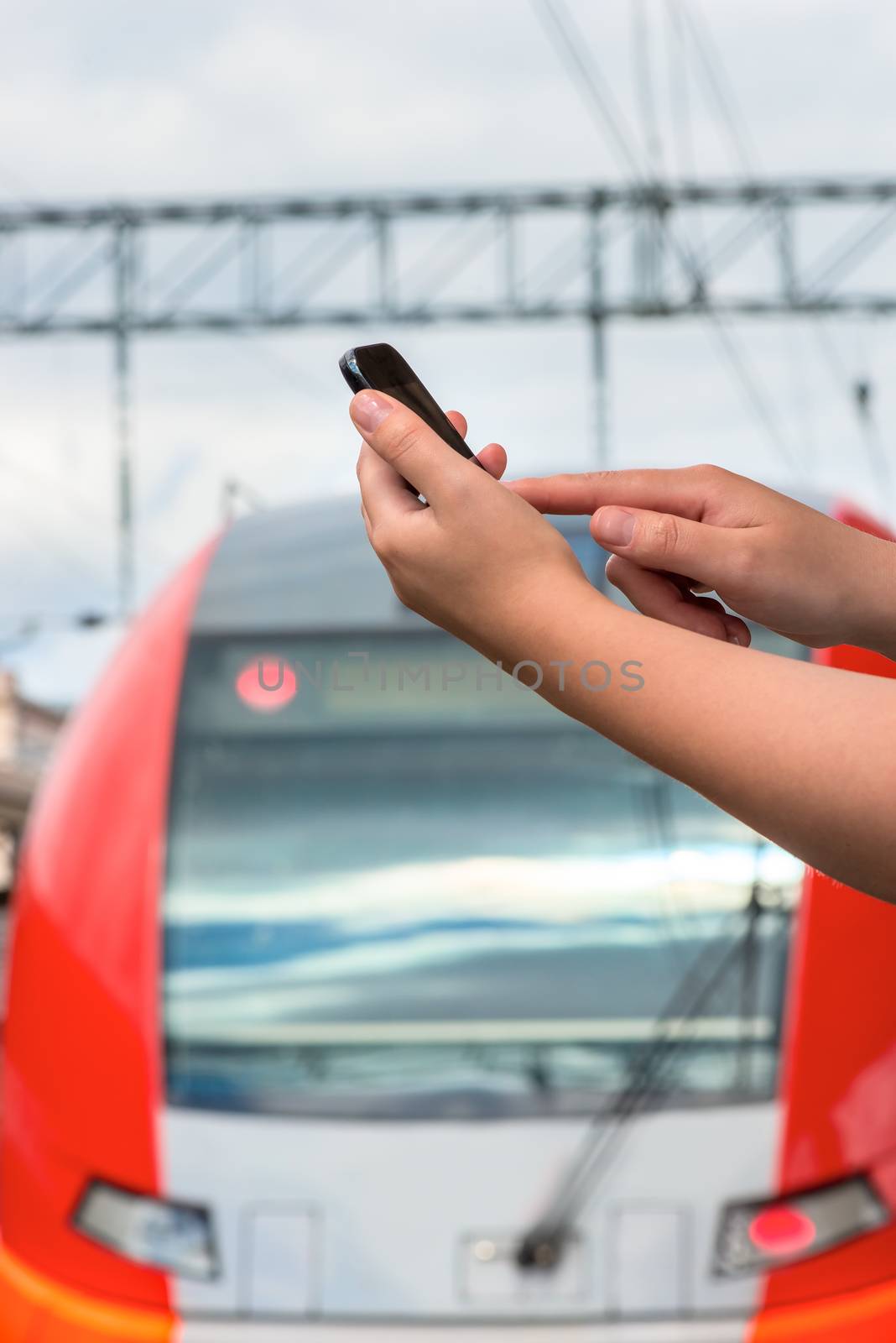 close-up, female hand with a mobile phone at railway station