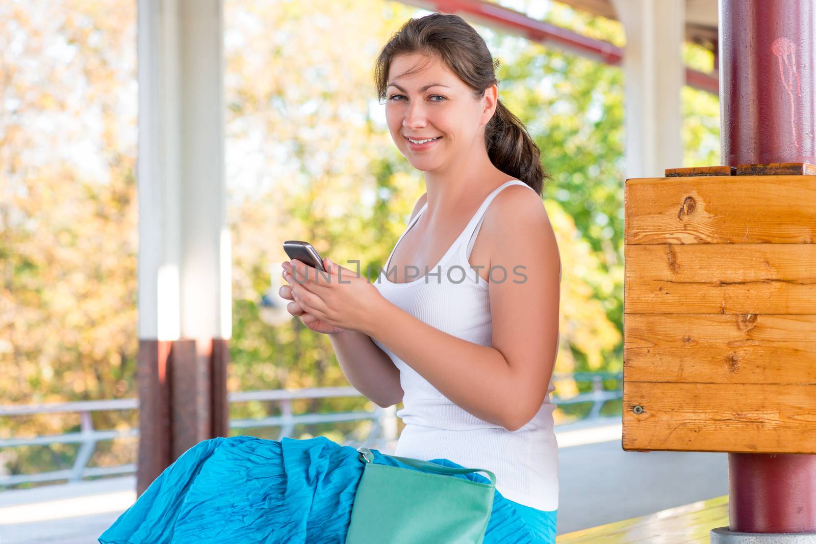 cheerful brunette girl with a phone at the station by kosmsos111