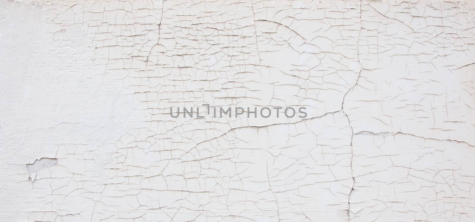 Old white wall with cracks, needs maintenance