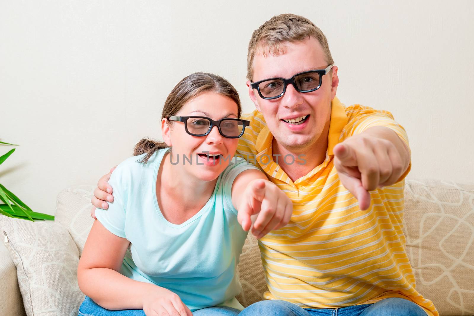 portrait of young couples looking TV in 3D glasses in the living room