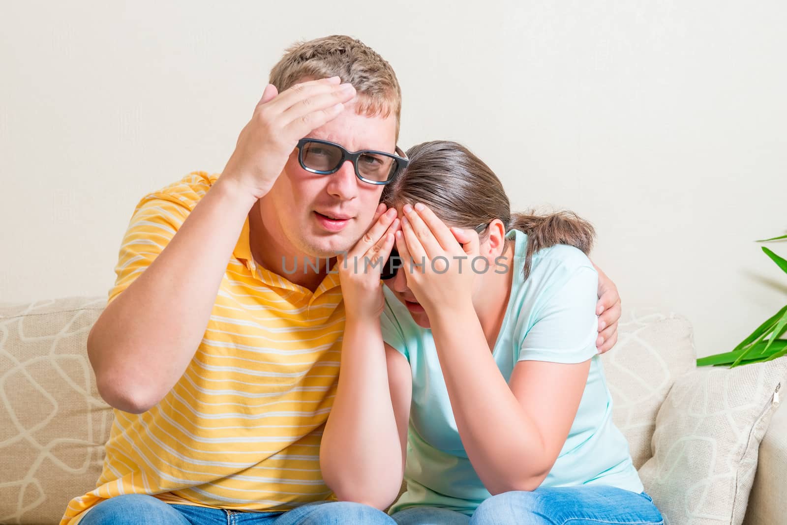 man and woman on the couch watching in 3D glasses scary movie