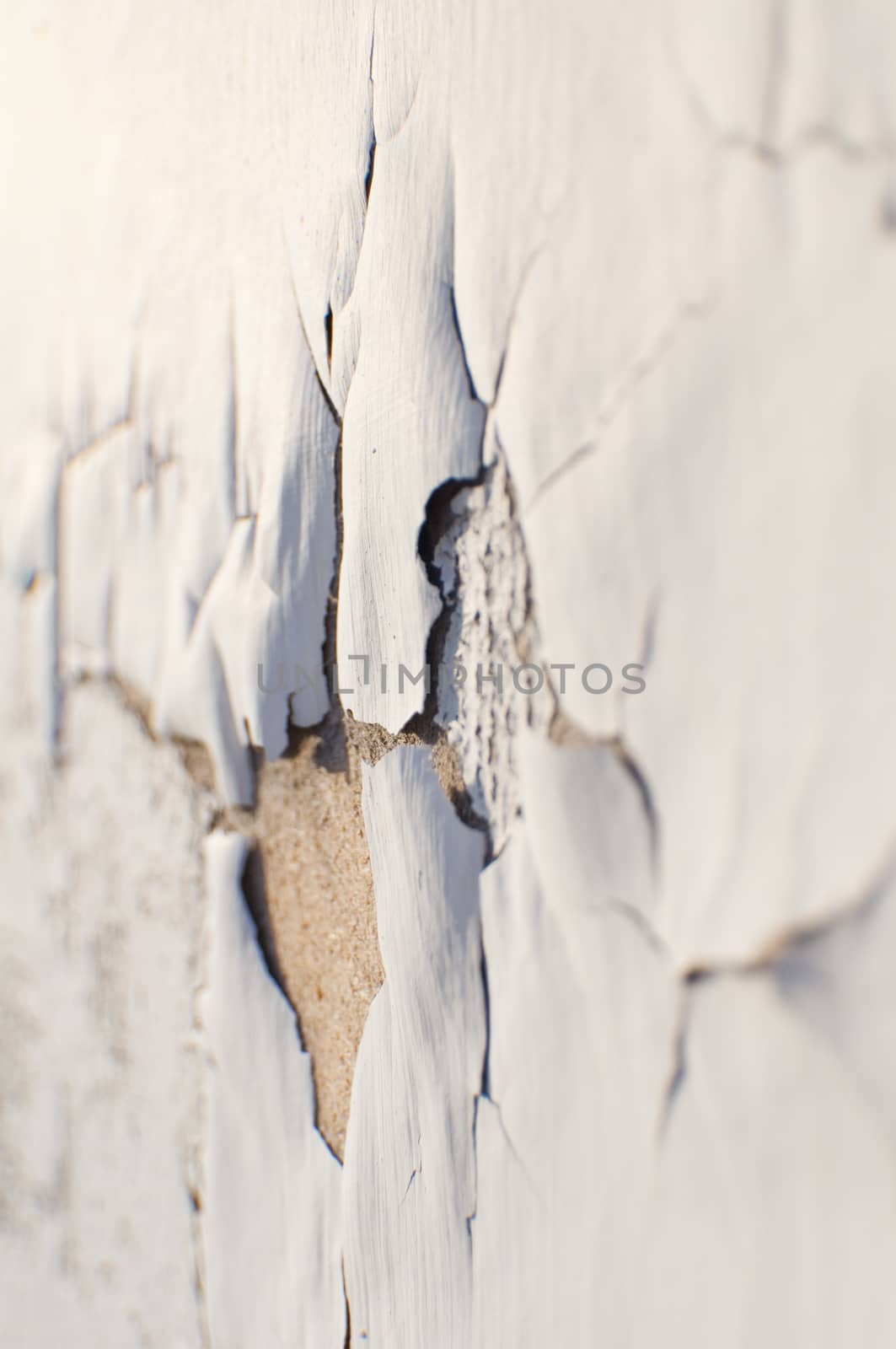 Whit paint cracking on the side of an abandoned building