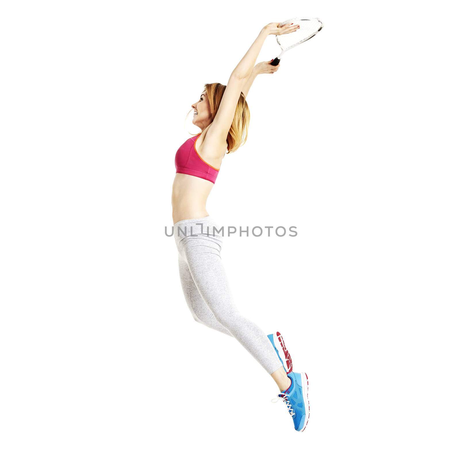 Sportswoman jumps up. She's on her tennis training. Studio shot isolated on white background.