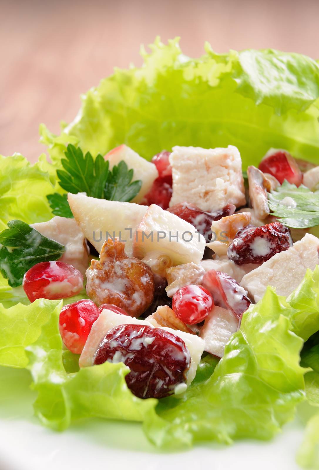 Salad with chicken, pomegranate, cranberries, walnuts seasoned in milk sauce lettuce leaves