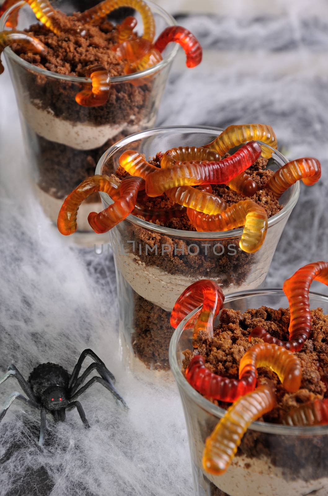 Dessert of chocolate sponge cake with cream and jelly worms