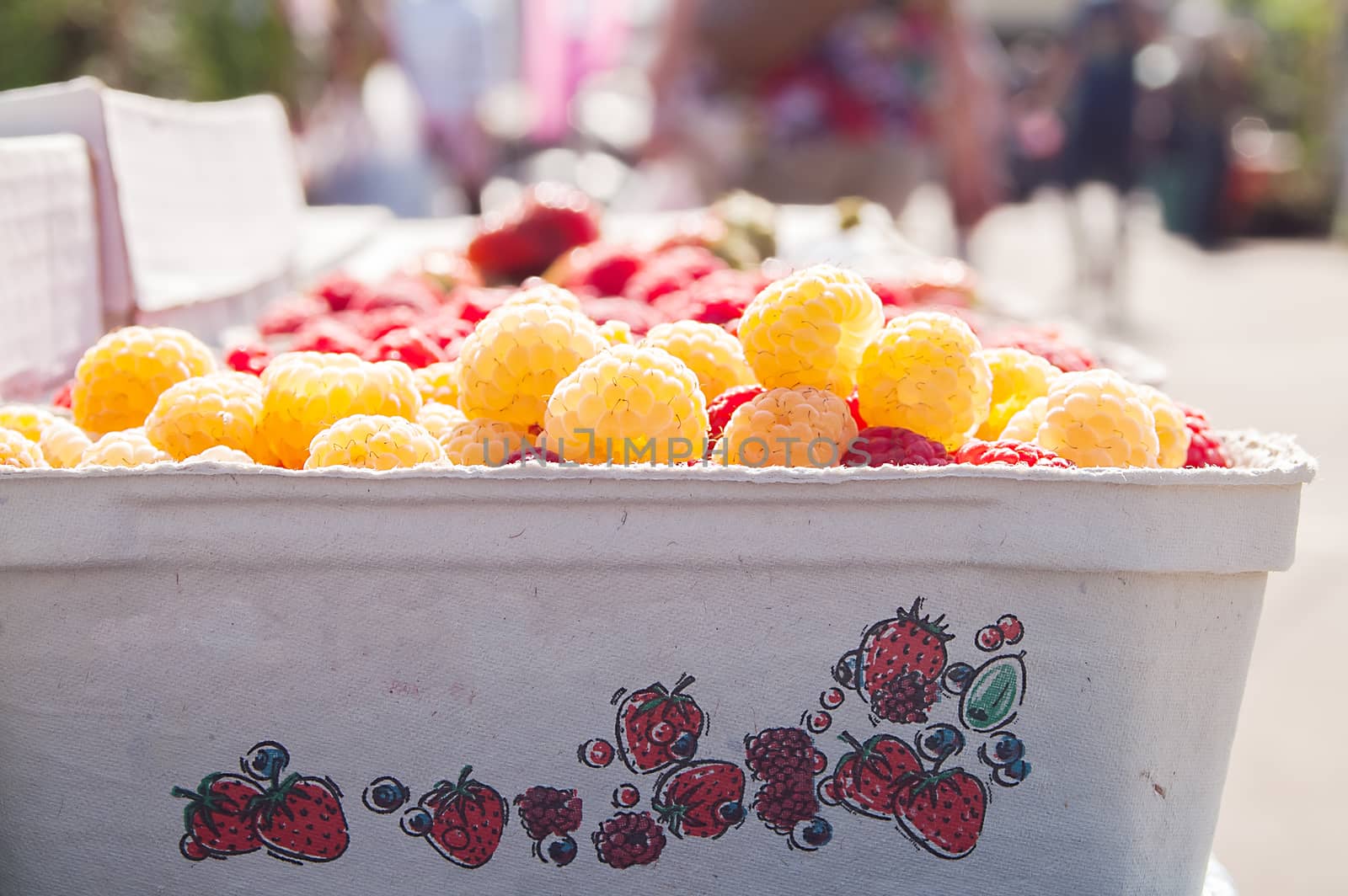 red  and yellow raspberries in a paper box by antonius_