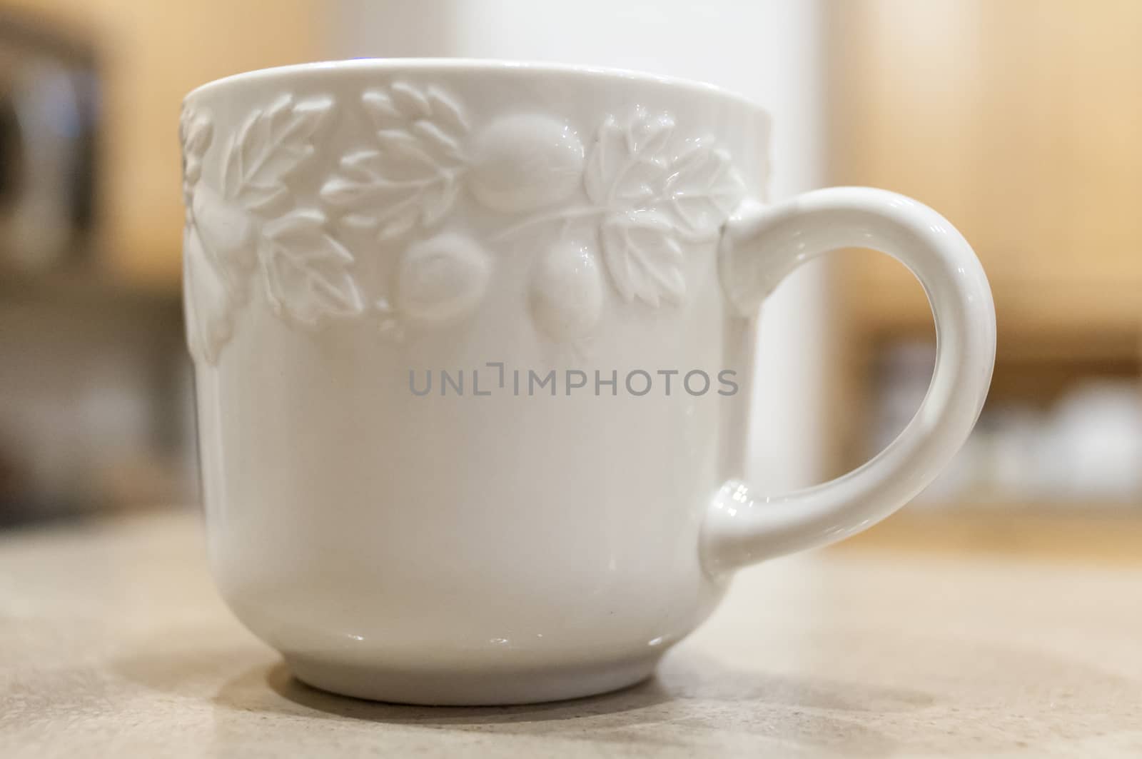 Small White Cofee Mug sitting no a Granite Countertop