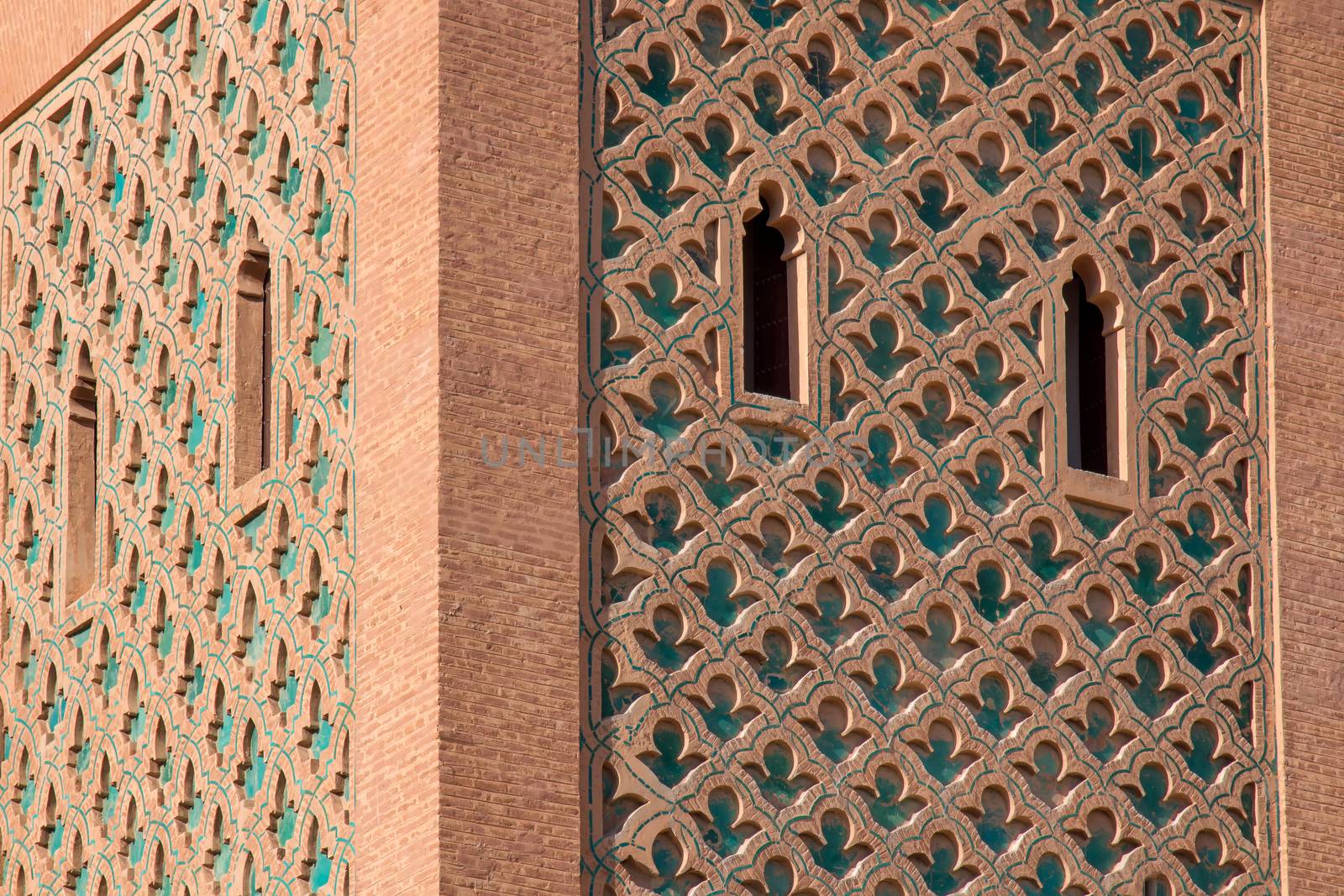 Tower of a famous mosque in medina of Marrakesh. Traditional details of the arabian architecture. Cloudy sky.