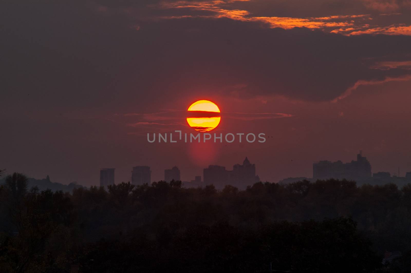 the sun at sunset with clouds over the city  by antonius_