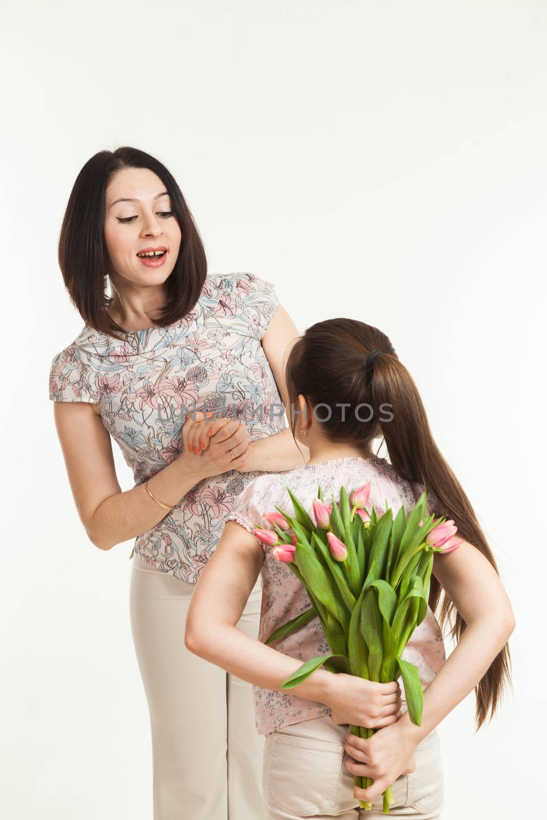 the girl hides a bouquet of flowers for mother by sveter
