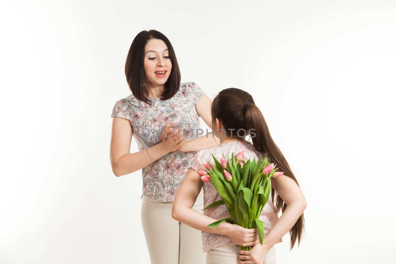 the girl hides a bouquet of flowers for mother by sveter