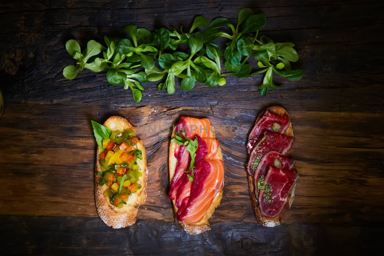 Various bruschettas on wooden table, top view