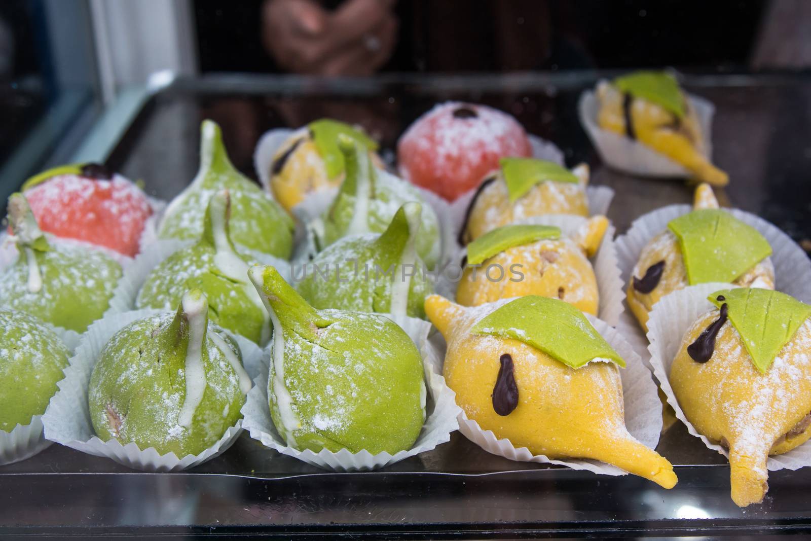 Shop window in Morocco with a tray full of beautiful pastry, in a shape of lemons and figs.