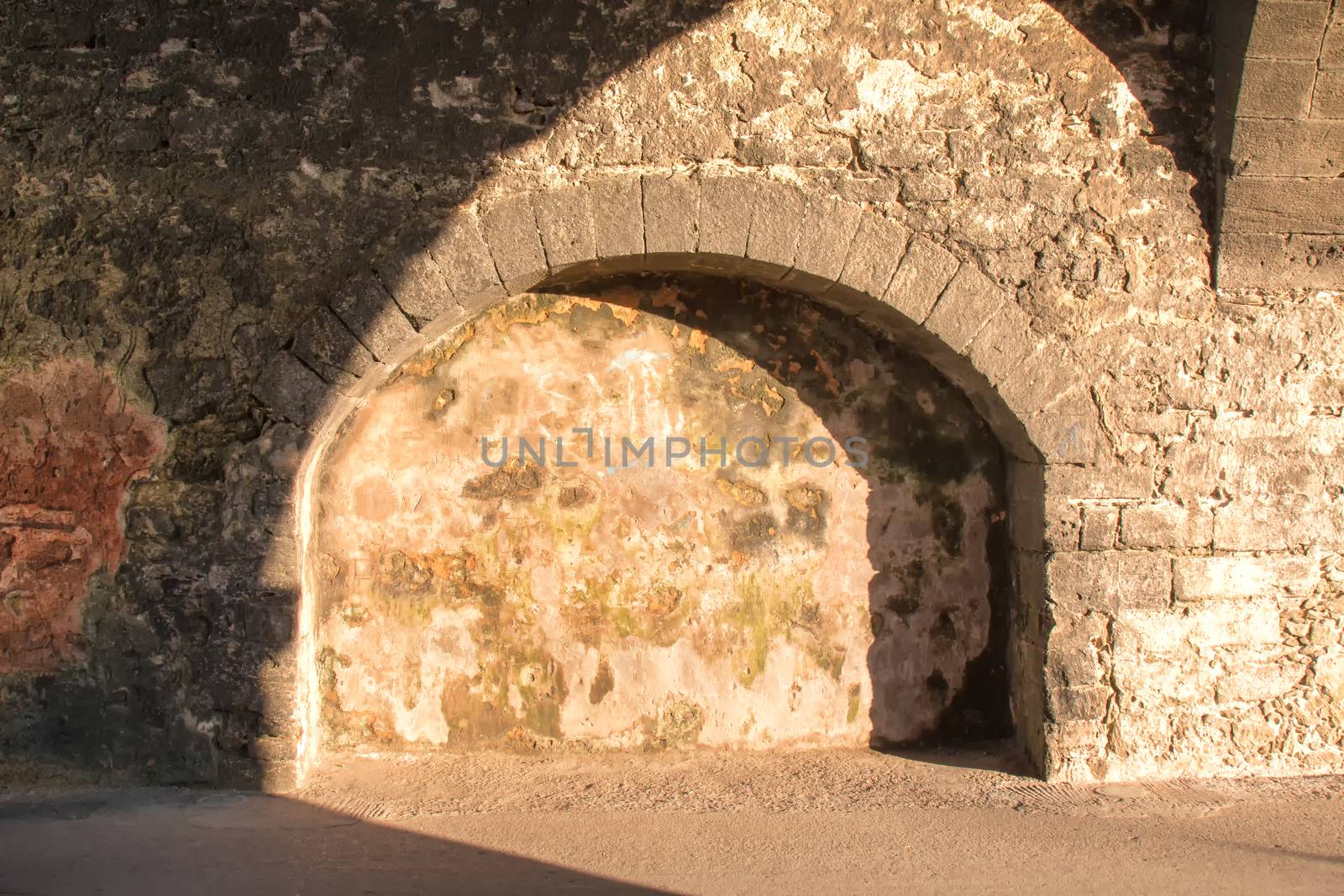 Shadow and light enlightening old underpass made of stones. Essaouira, Morocco.