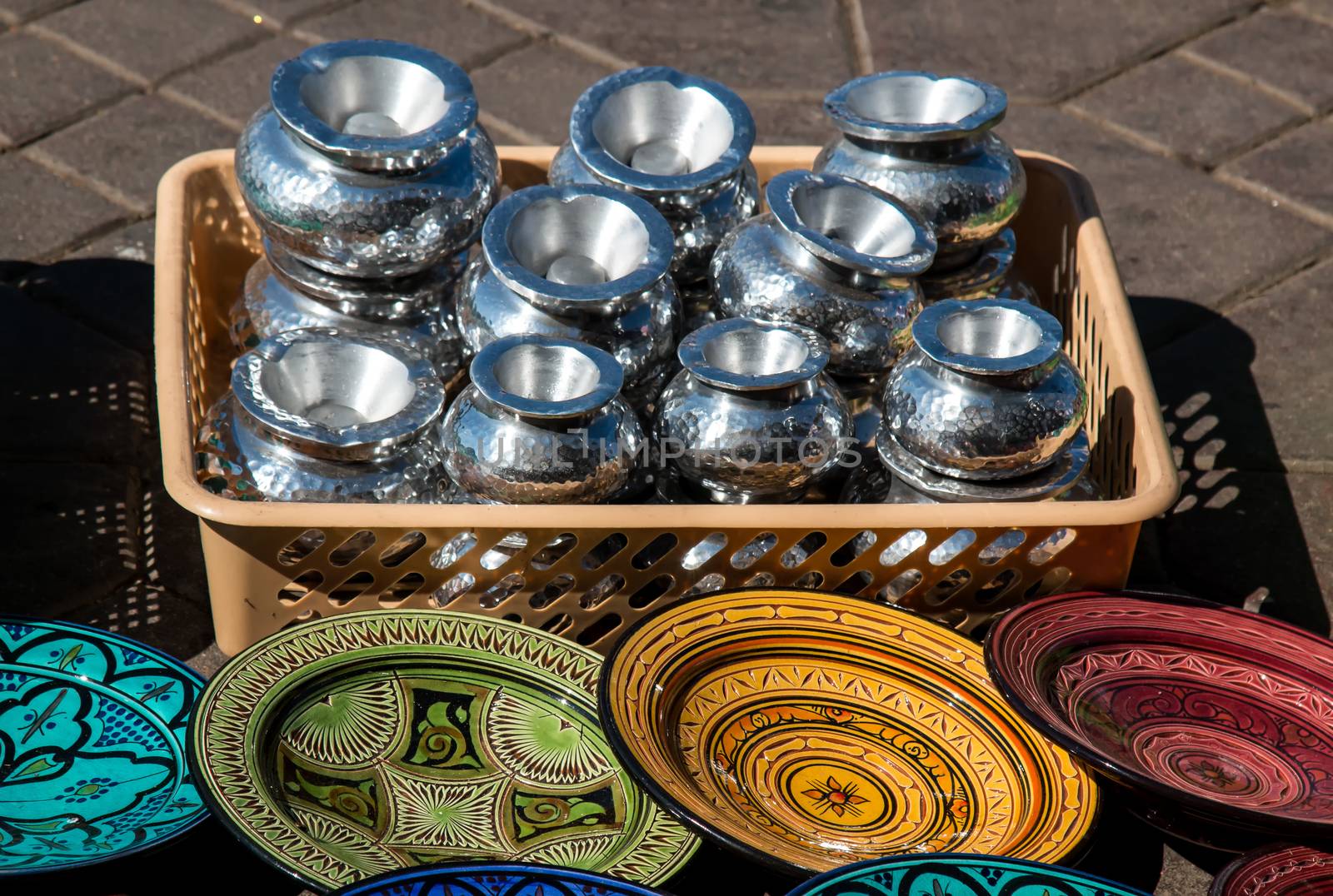 Offer on the path: basket full of silver ashtrays and various colors and decorations of the traditional plates.