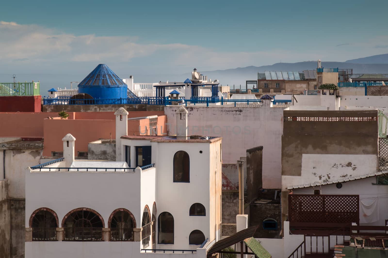 View from a roof of a house on the city Essaouira. Intense clouds. Mountains in the background.