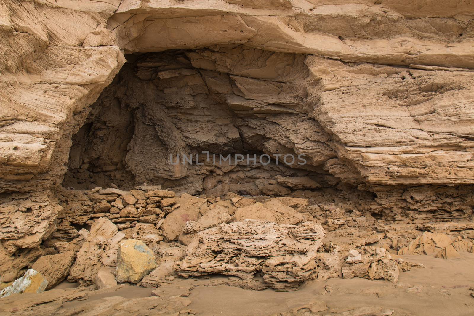 Sandy color of the stones and rocks with a cave. Atlantic coast in Morocco.