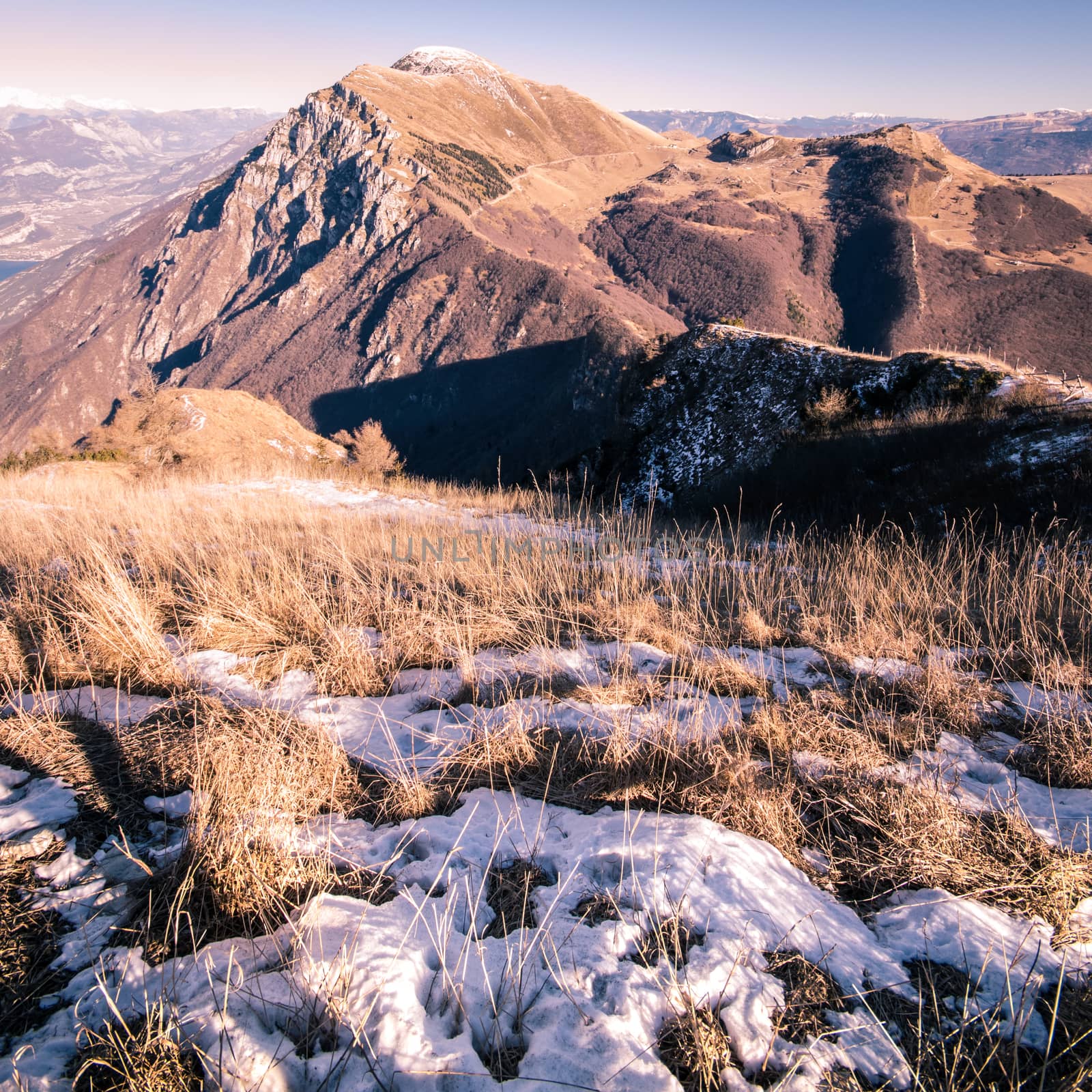 The spring sun warms the mountains with meadows still partially covered with snow.