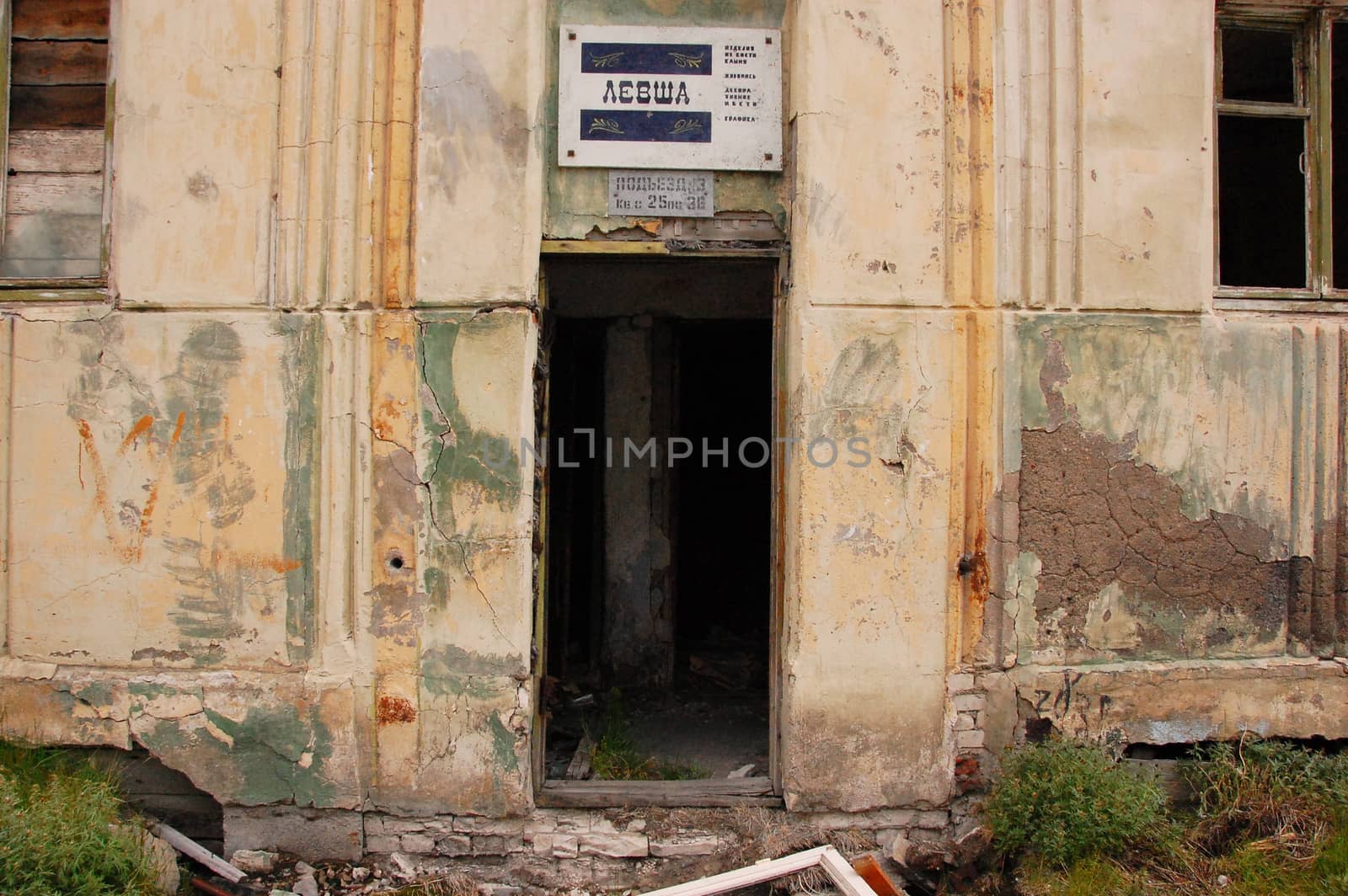 Old information sign above abandoned building entrance, Pevek town, Chukotka, Russia