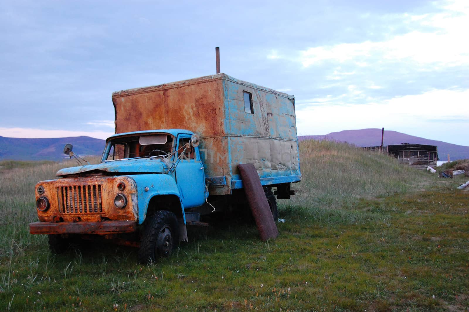 Abandoned broken mud hut at arctic summer tundra, Routan Island, Chukotka, Russia