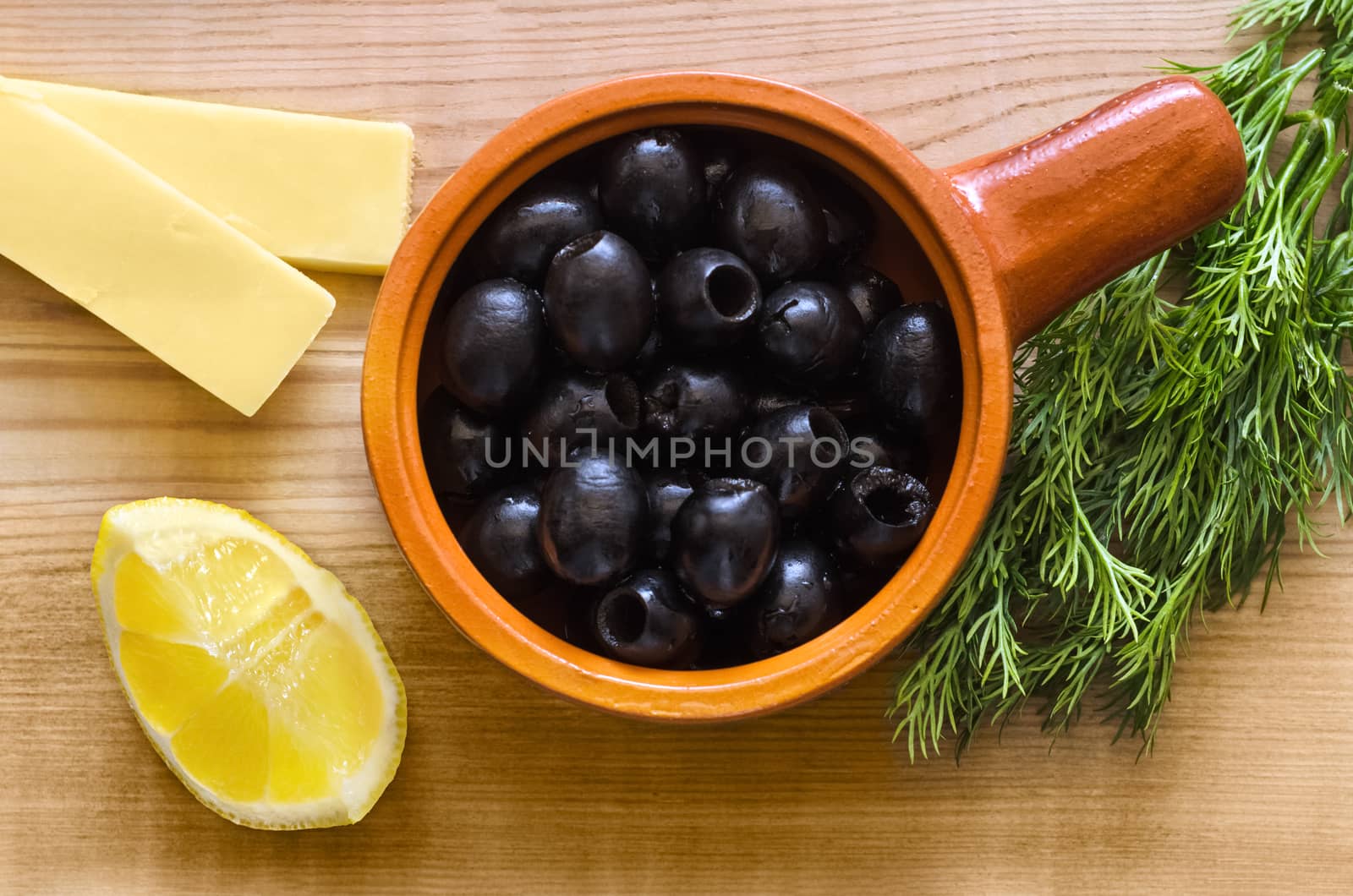 Black olives in a Cup on the table by Gaina