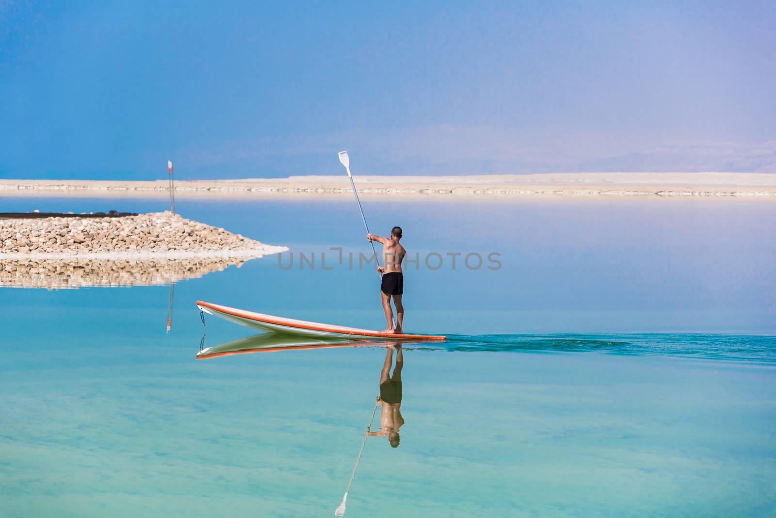 man floats on a boat in the dead sea