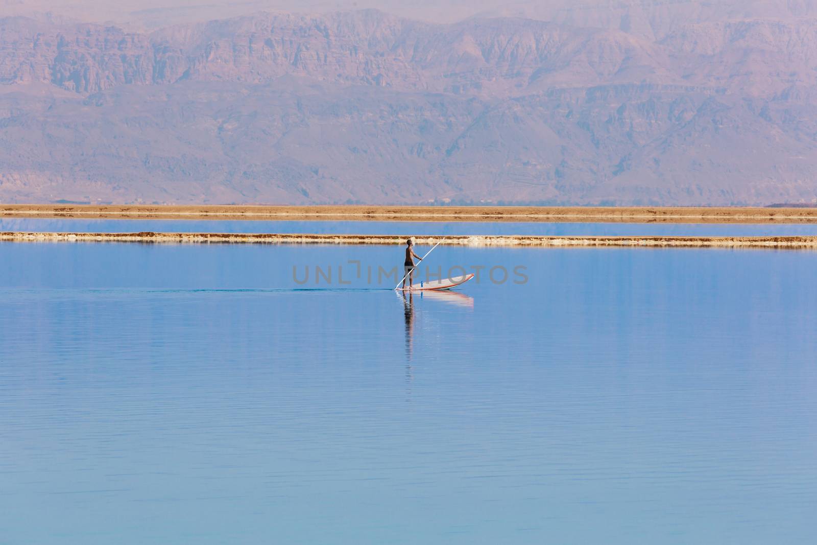 man floats on a boat in the dead sea