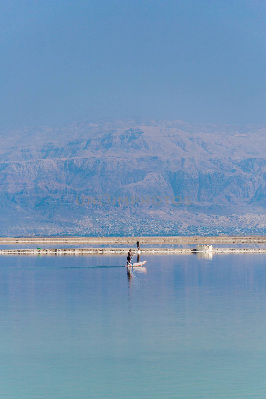 man floats on a boat in the dead sea