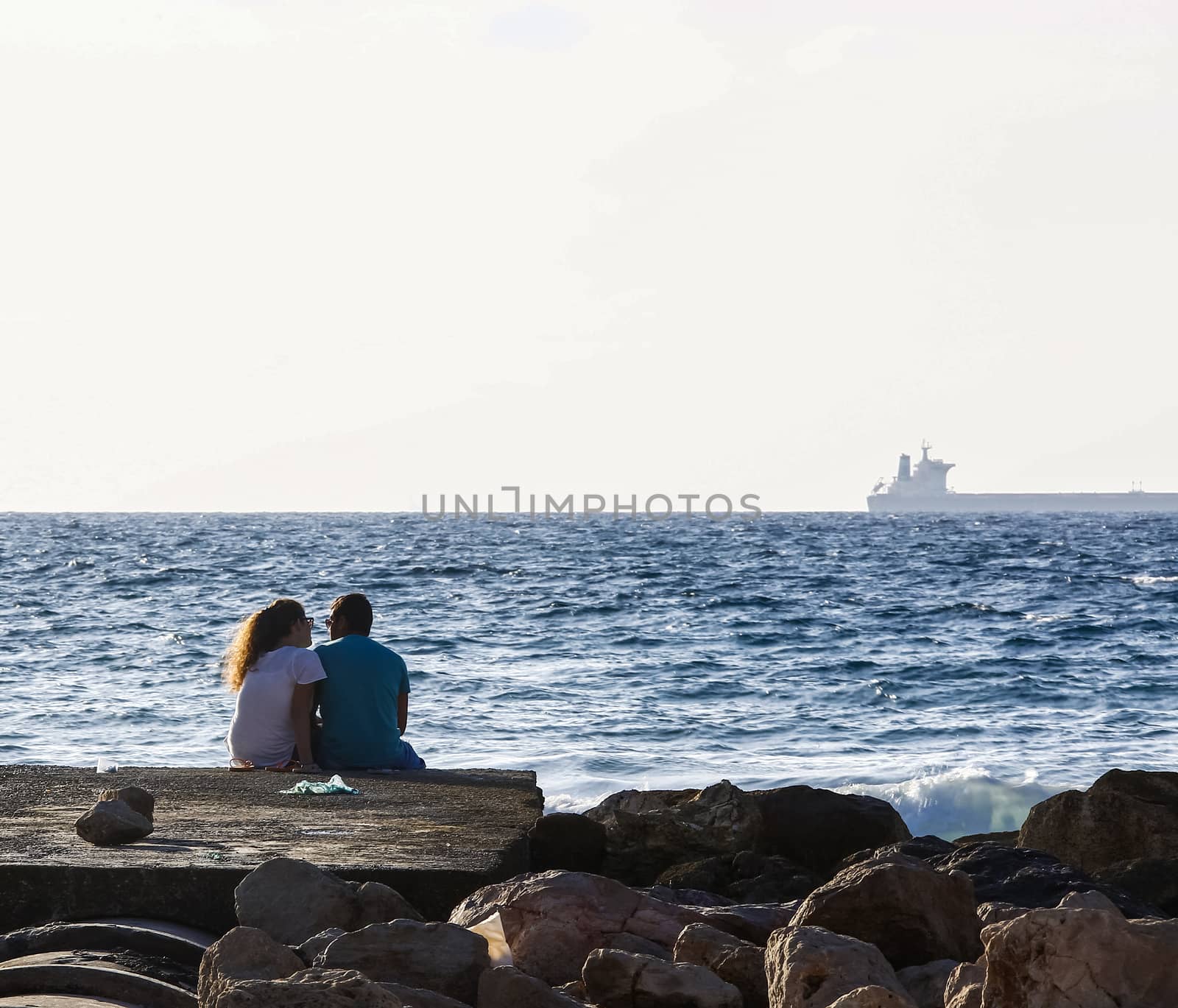 man and woman sitting on the coast