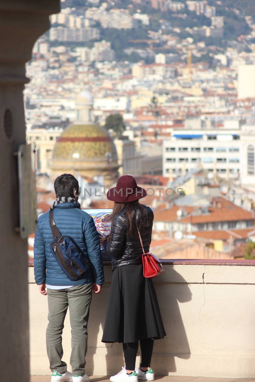 Nice, France - November 30 2015: Back View of Young asian Couple in Love in front of an Aerial View of the City of Nice, France