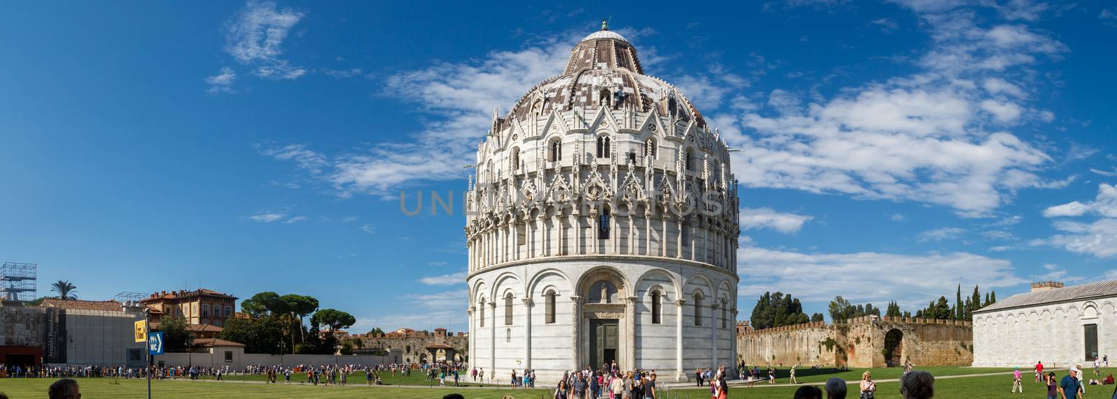 PISA, ITALY - SEPTEMBER 21, 2015 : View of Baptisery building in Cathedral Square in Pisa, Italy, on cloudy blue sky background.
