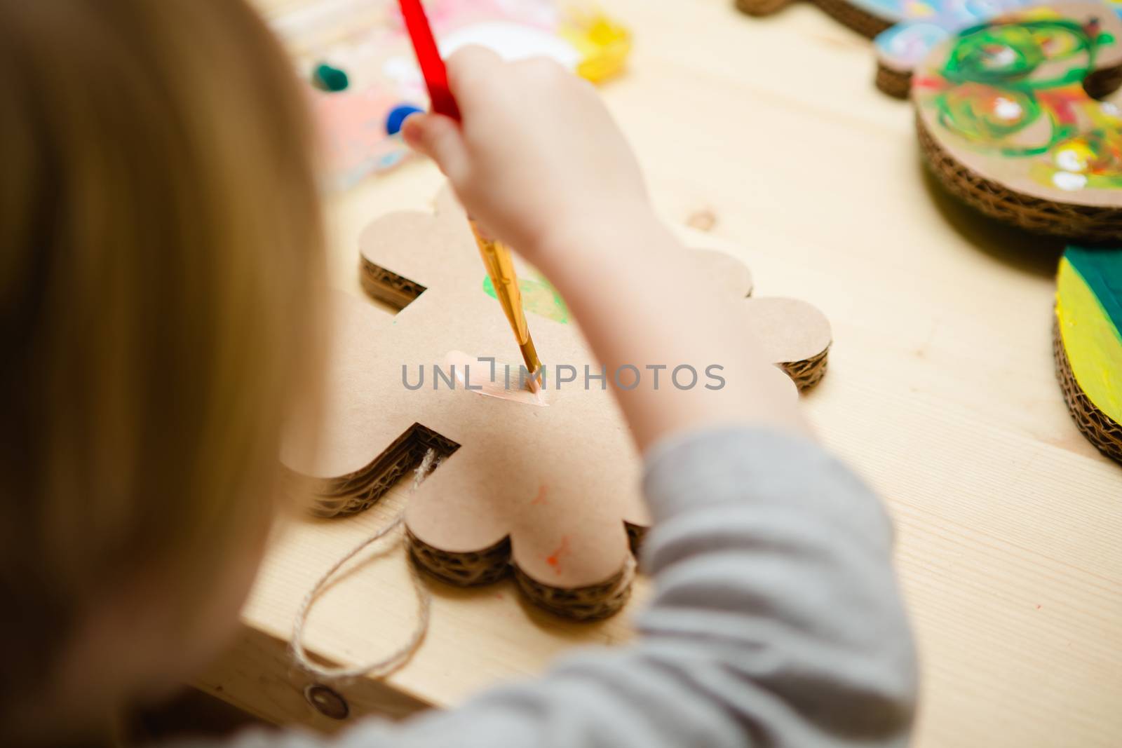 Little female baby painting with colorful paints by sarymsakov