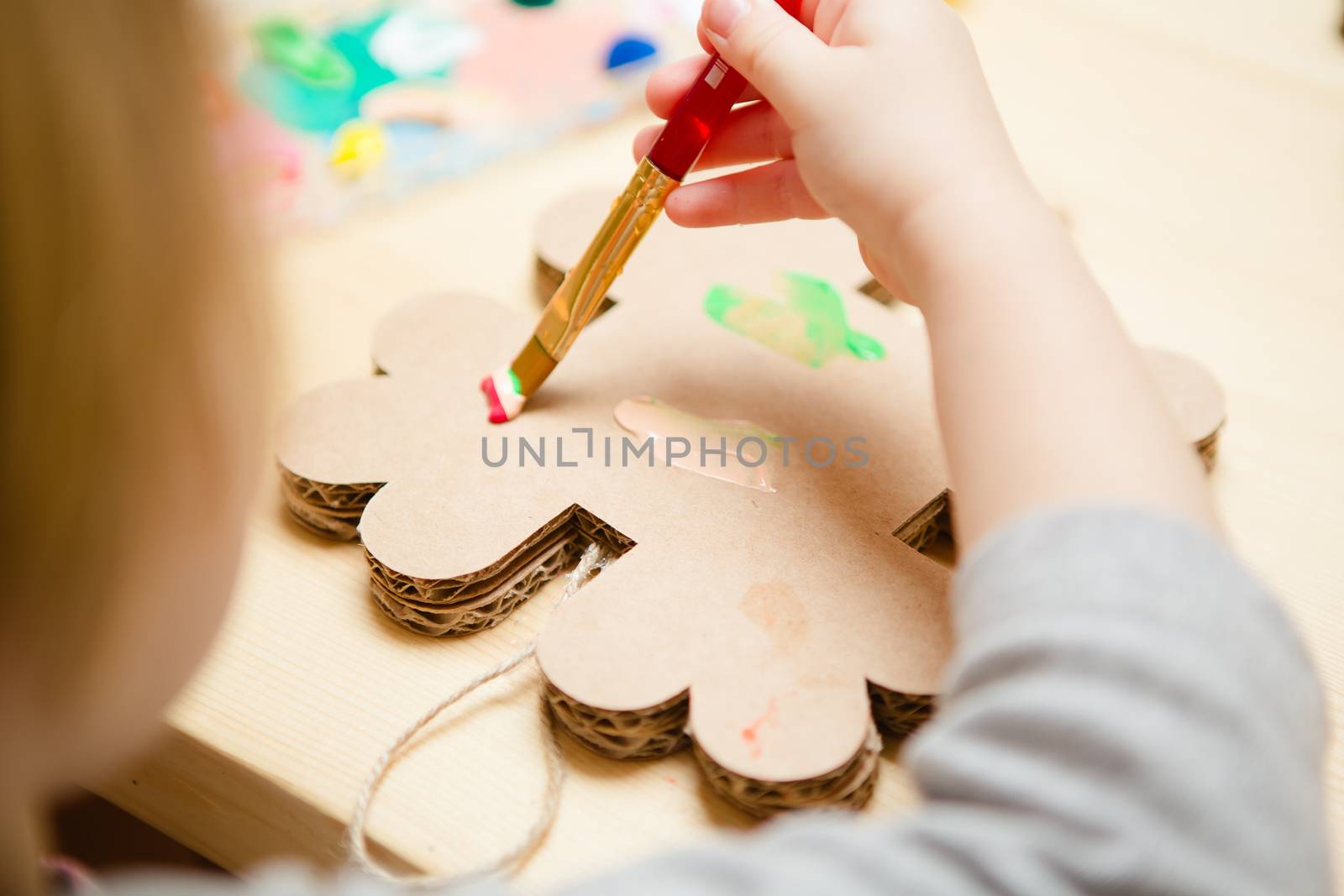 Little female baby painting with colorful paints. selective focus