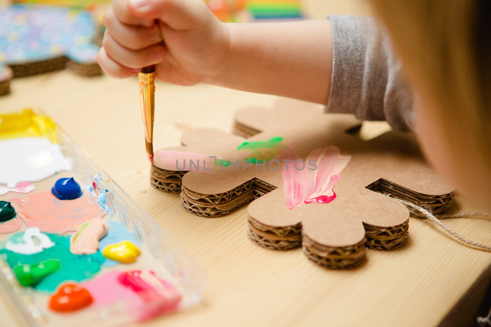 Little female baby painting with colorful paints. selective focus