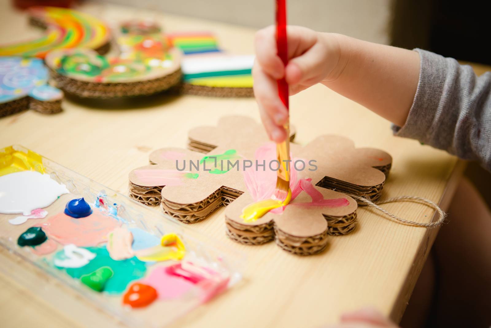 Little female baby painting with colorful paints. selective focus