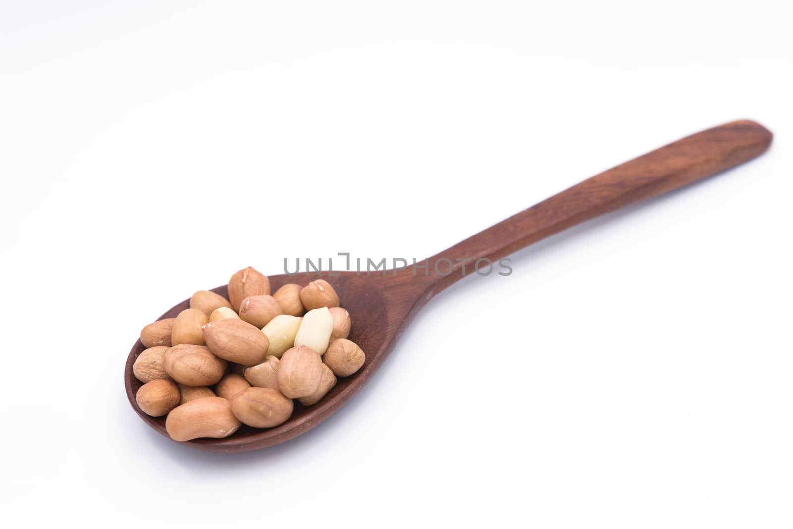 Peanut in wooden spoon on white background