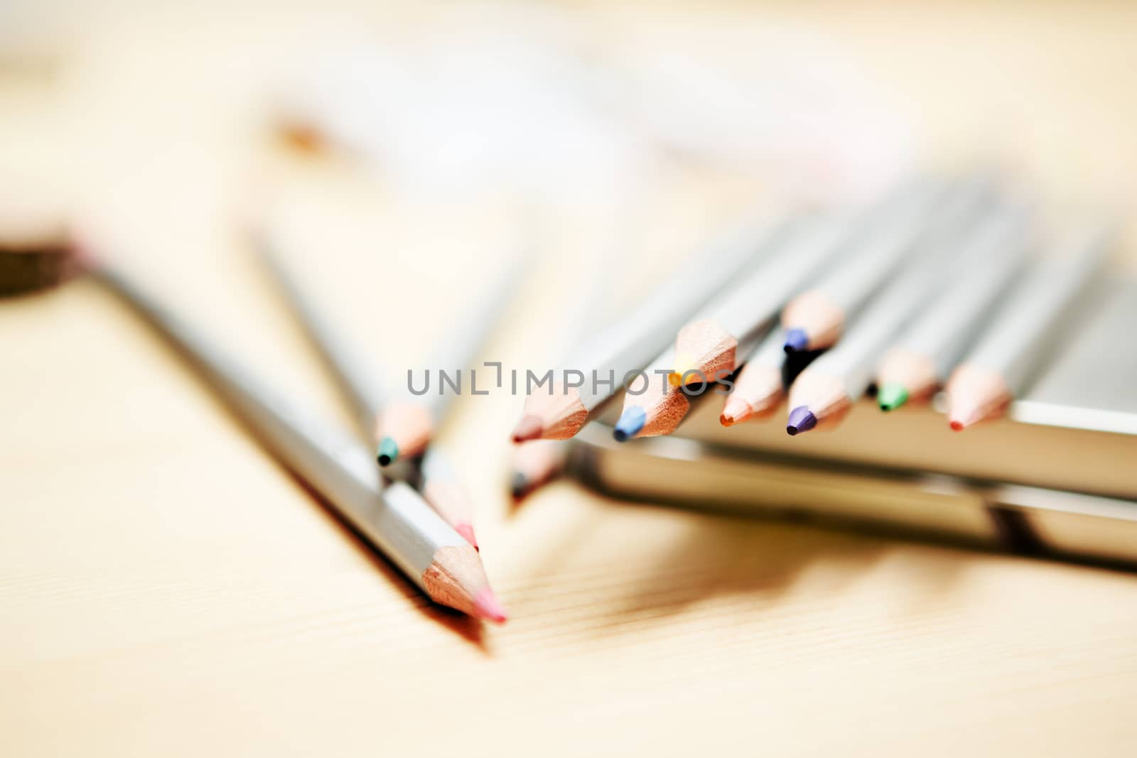 Close up of color pencils over wooden background by sarymsakov